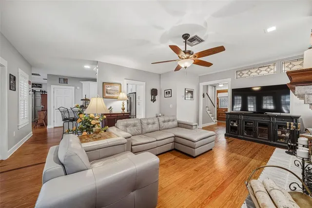a living room with furniture kitchen view and a window