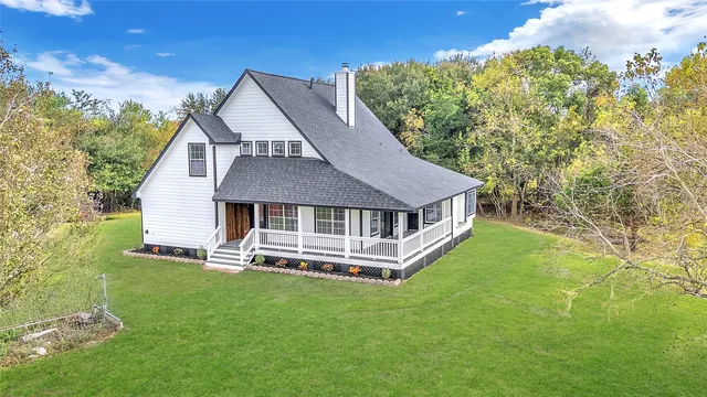 a aerial view of a house with a yard table and chairs