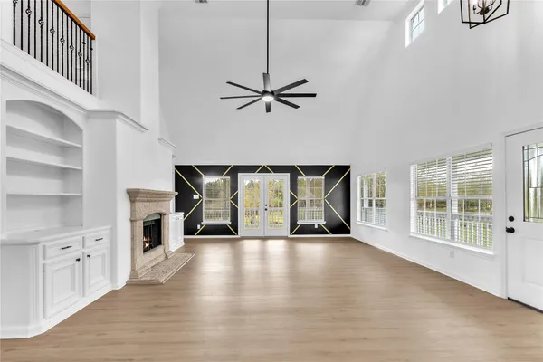 a view of an empty room with a window and kitchen view