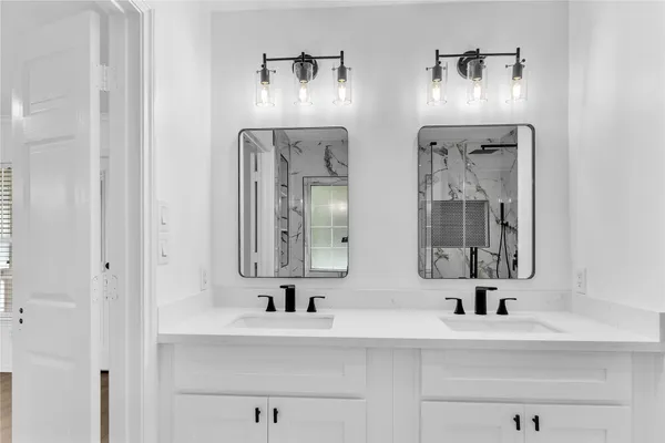 a bathroom with double vanity sinks and a mirror