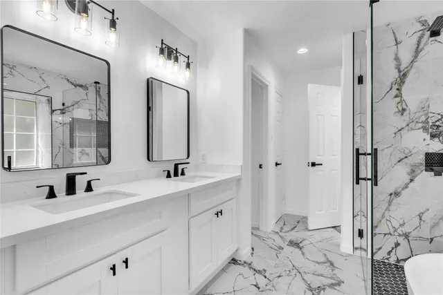 a bathroom with double vanity sinks a toilet a mirror and shower