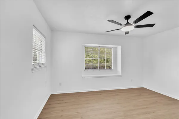 a view of a big room with wooden floor closet and windows