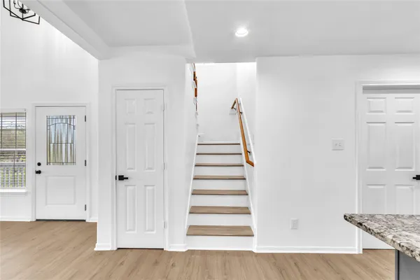 a view of a hallway with wooden floor and entryway
