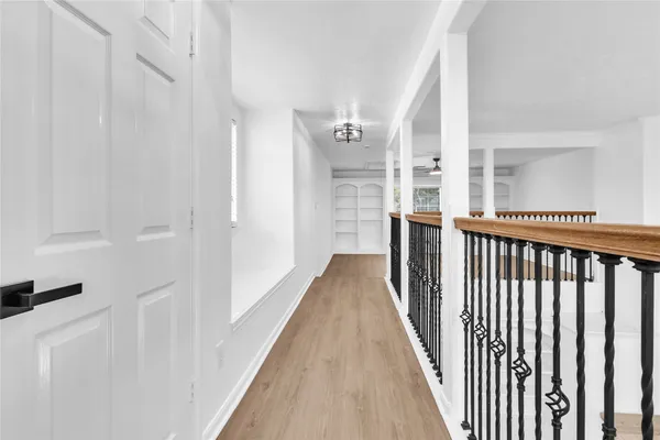 a view of a hallway with wooden floor and staircase