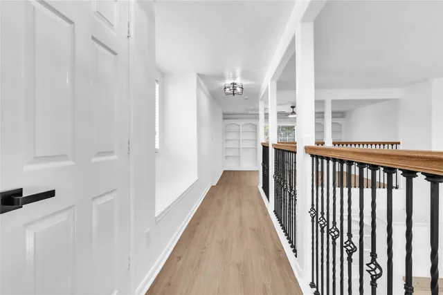 a view of a hallway with wooden floor and staircase