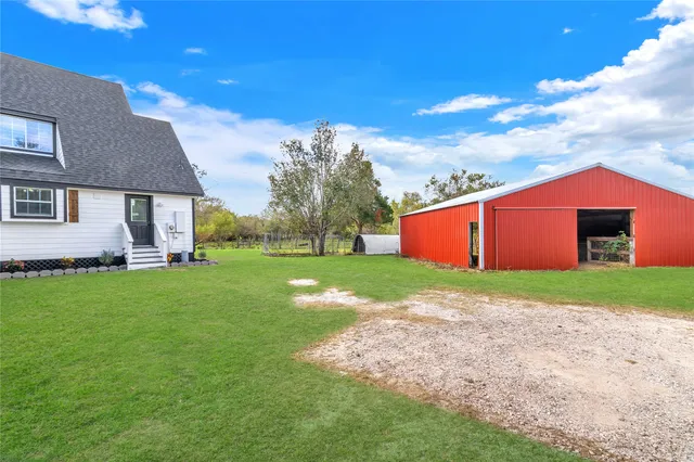 a view of backyard of house with green space