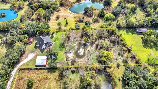 an aerial view of house with yard and swimming pool