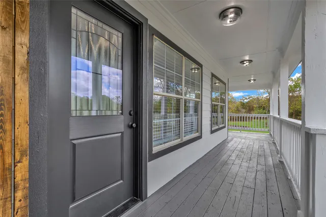 a view of hallway with a large window and wooden floor