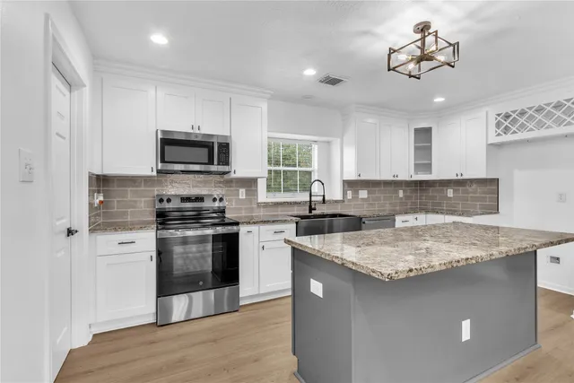 a kitchen with a sink stove and microwave