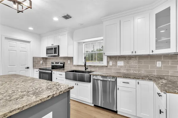 a kitchen with granite countertop cabinets stainless steel appliances and a counter space