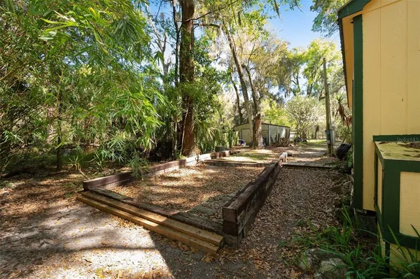 a backyard of a house with table and chairs under an umbrella