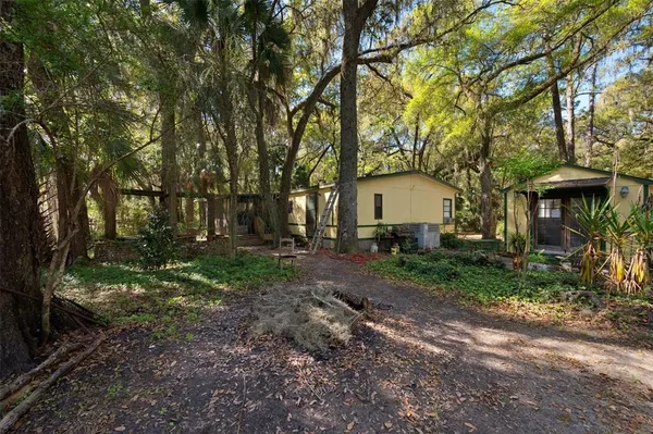 a view of a house with backyard and trees
