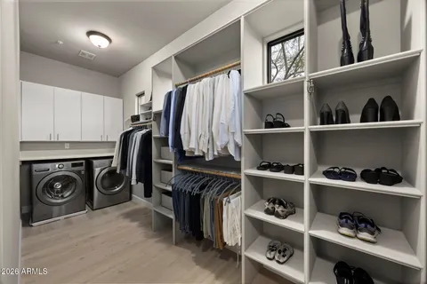 a view of walk in closet with clothes and shoes