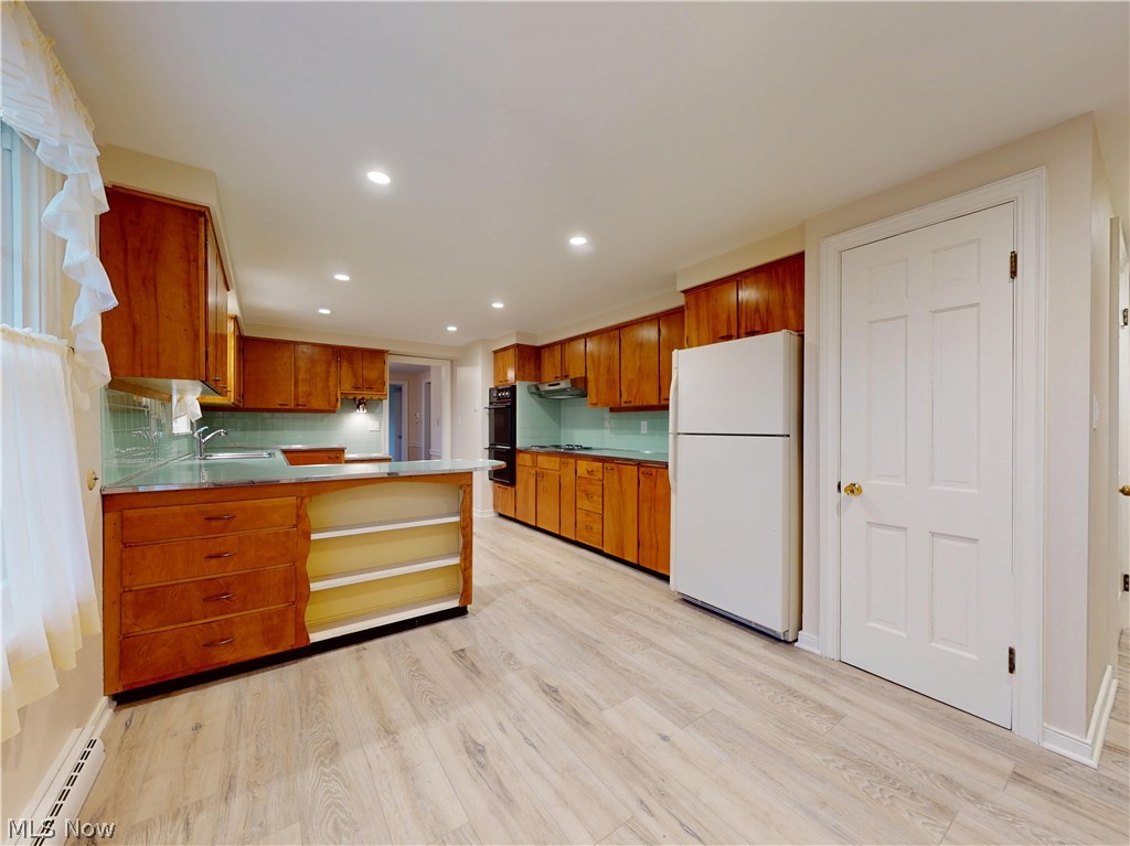 145 Overlook Road Painesville, OH 44077 - Photo 20 of 36 Kitchen featuring a peninsula, wood finish cabinetry, recessed lighting, freestanding refrigerator, and open shelves