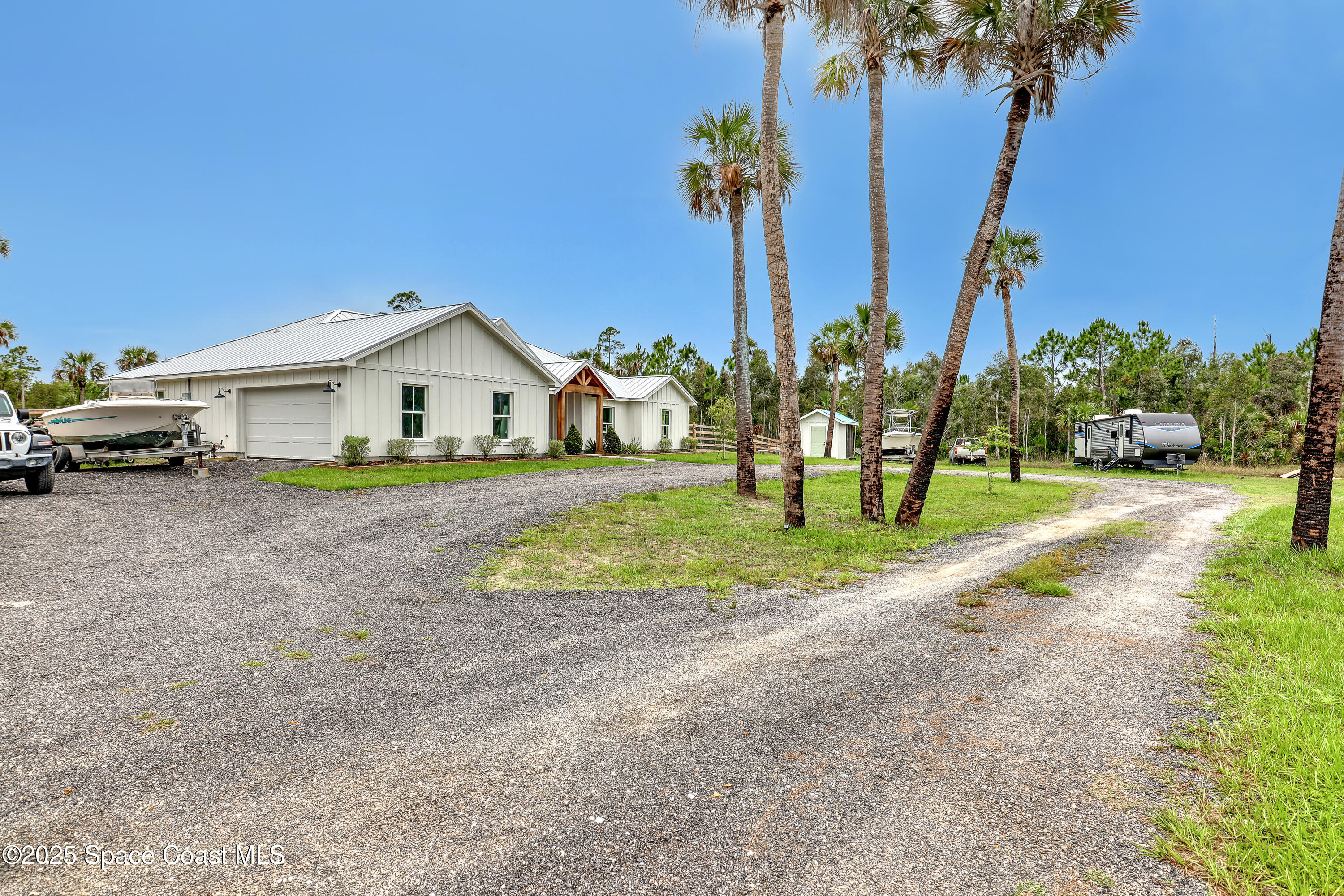 3350 Leghorn Road Malabar, FL 32950 - Photo 3 of 55 a view of a house with a yard and palm trees