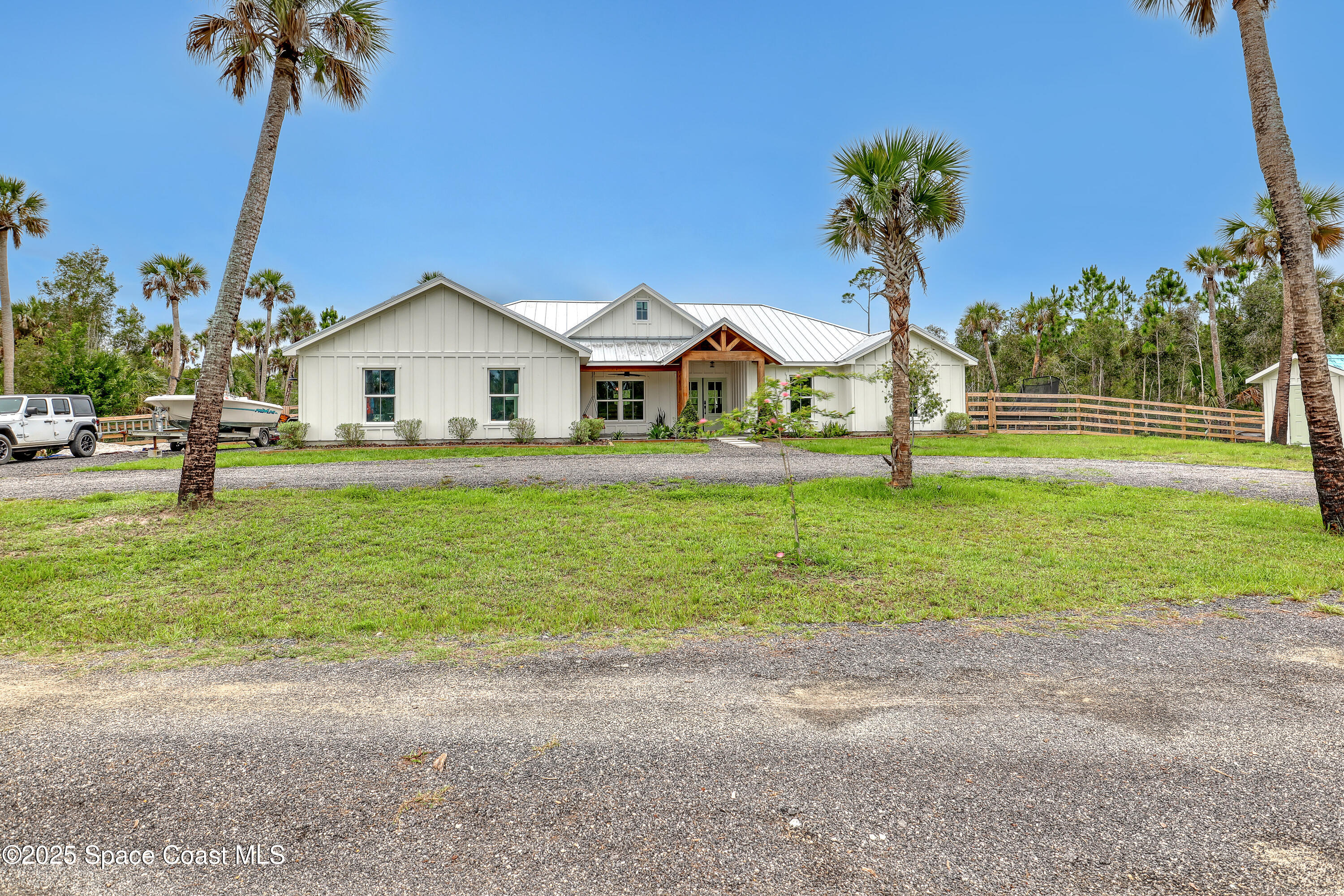 3350 Leghorn Road Malabar, FL 32950 - Photo 4 of 55 a front view of a house with a yard and palm trees