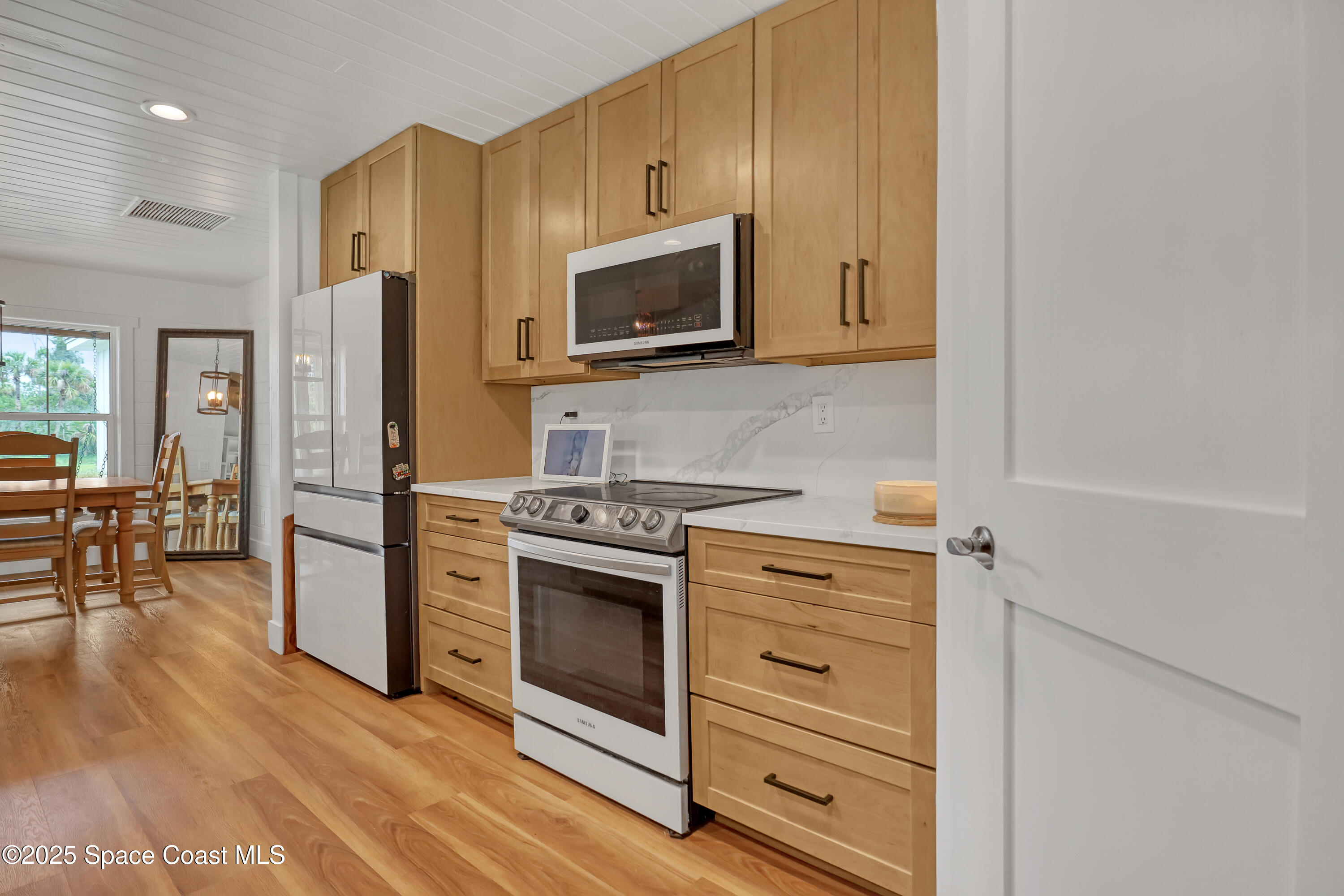 3350 Leghorn Road Malabar, FL 32950 - Photo 55 of 55 a kitchen with stainless steel appliances white cabinets and a stove top oven