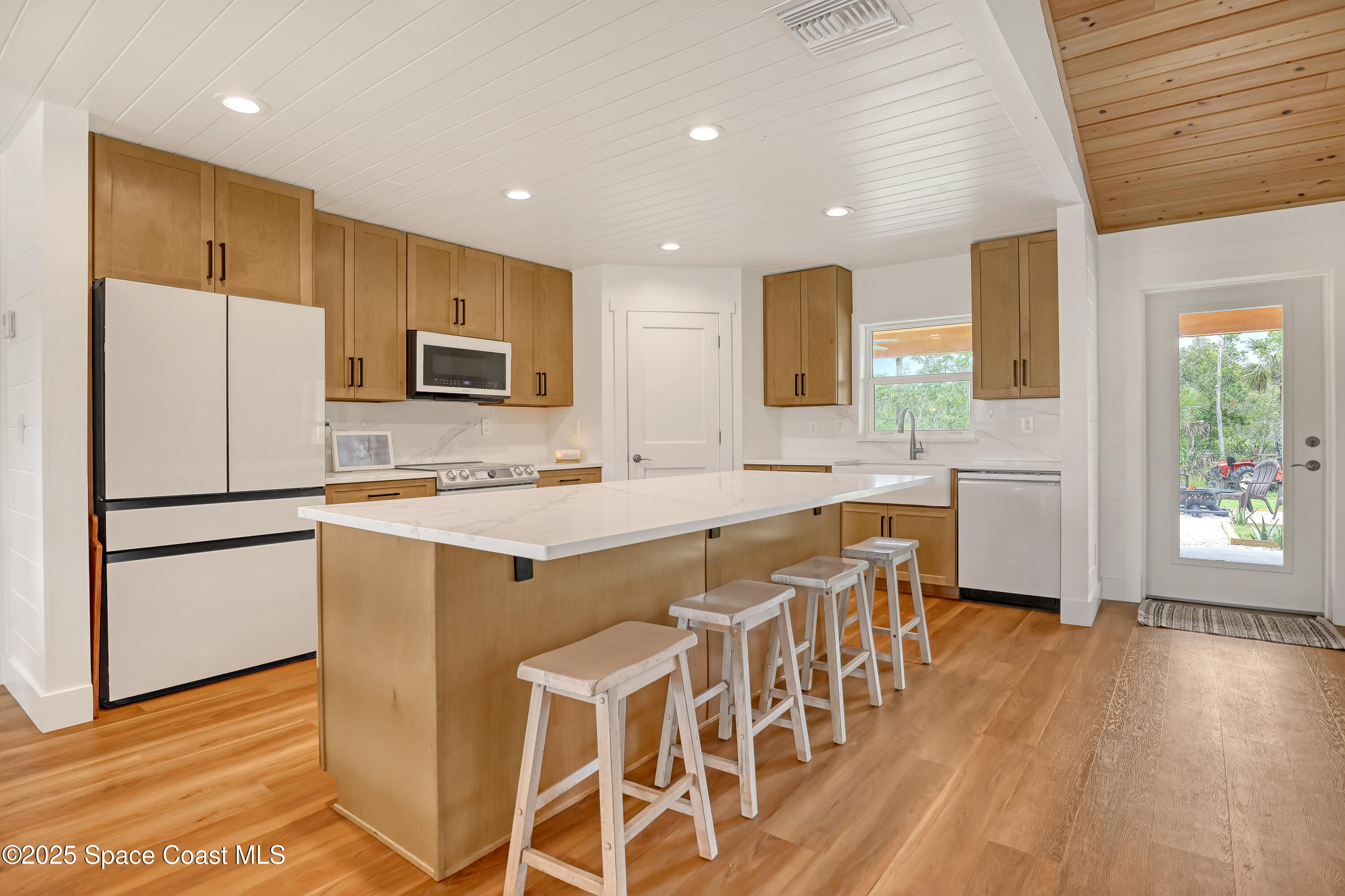 3350 Leghorn Road Malabar, FL 32950 - Photo 8 of 55 a kitchen with stainless steel appliances granite countertop a refrigerator a sink dishwasher a stove with white cabinets and wooden floor