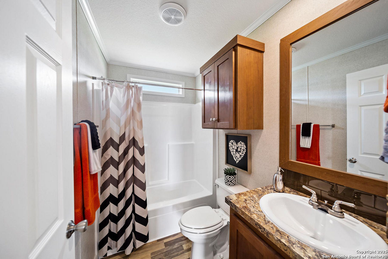 113 County Road 2644 Devine, TX 78057 - Photo 10 of 14 a bathroom with a granite countertop sink toilet and shower
