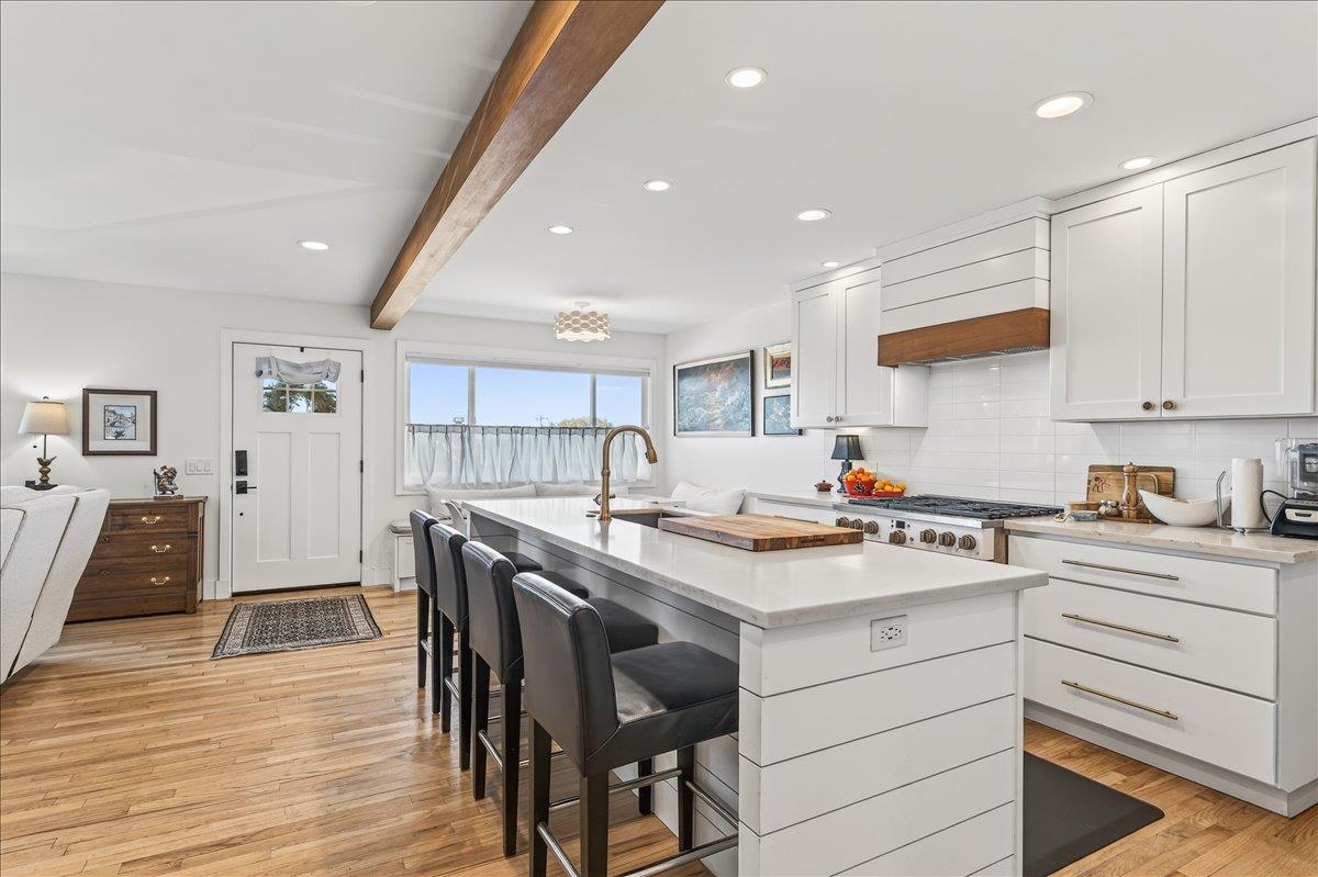 1232 Vallejo Street Seaside, CA 93955 - Photo 14 of 42 a kitchen with a stove a refrigerator and white cabinets with wooden floor