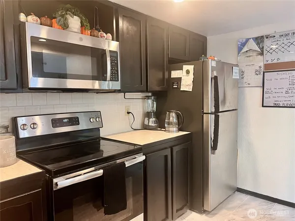 a kitchen with stainless steel appliances a stove microwave and refrigerator