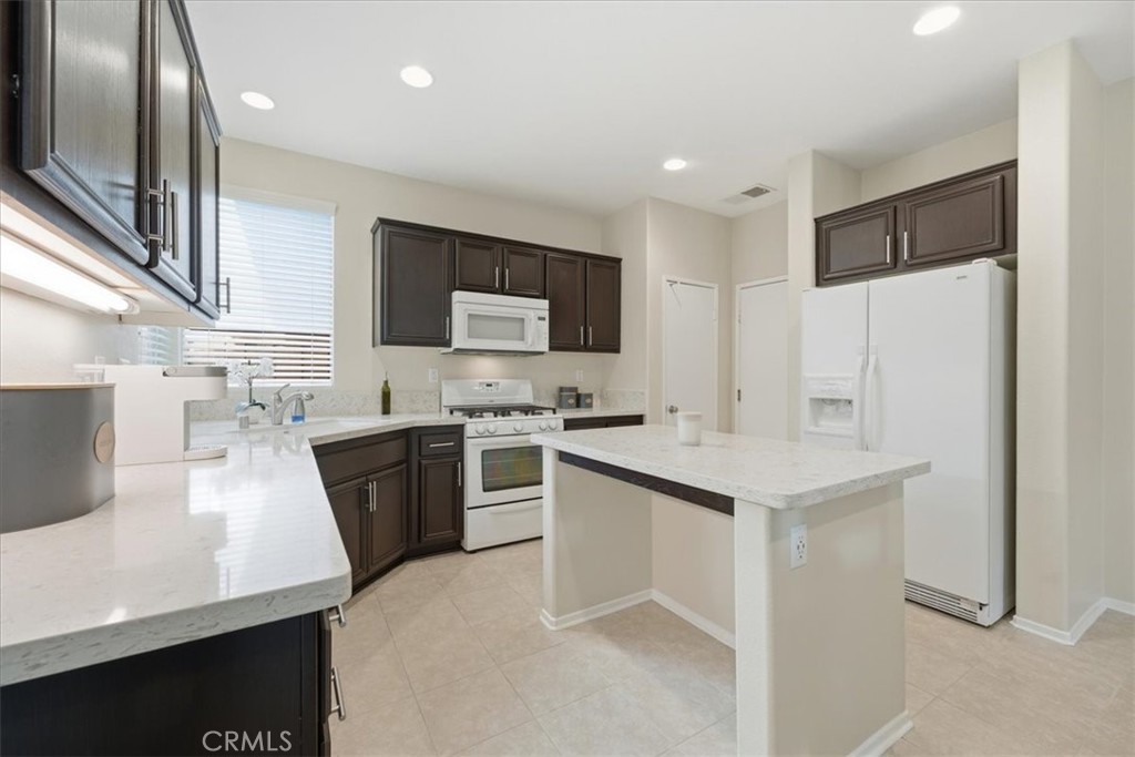 4674 Trailmore Court Riverside, CA 92505 - Photo 13 of 45 a large kitchen with a sink stainless steel appliances and cabinets
