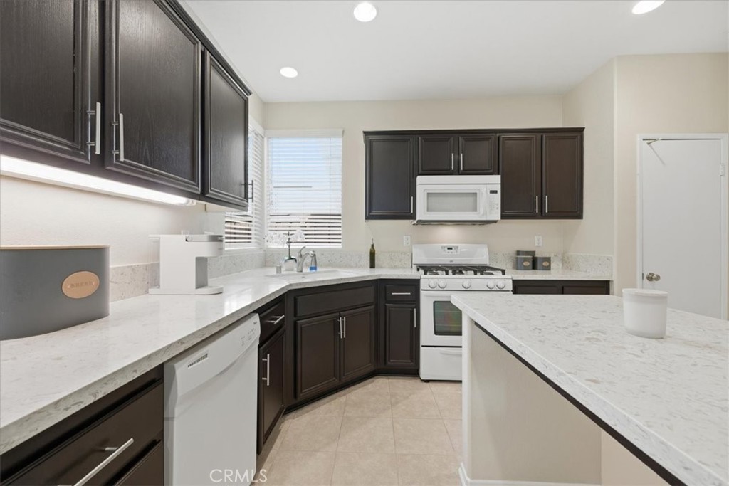 4674 Trailmore Court Riverside, CA 92505 - Photo 15 of 45 a kitchen with stainless steel appliances granite countertop a sink stove and refrigerator