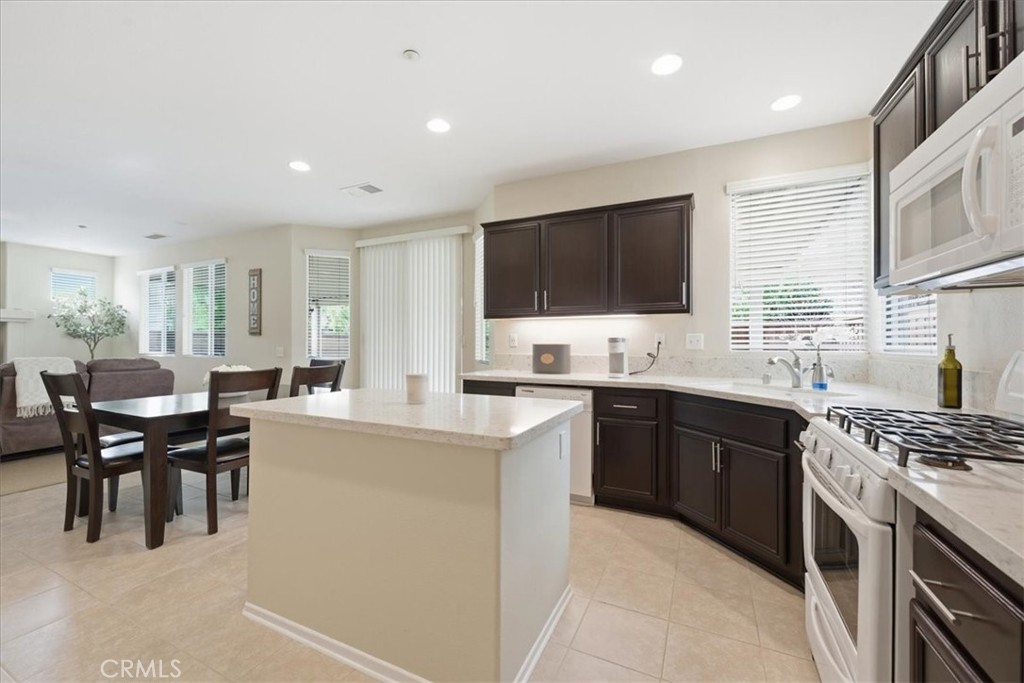 4674 Trailmore Court Riverside, CA 92505 - Photo 16 of 45 a kitchen with stainless steel appliances kitchen island granite countertop a stove a sink a dining table and chairs