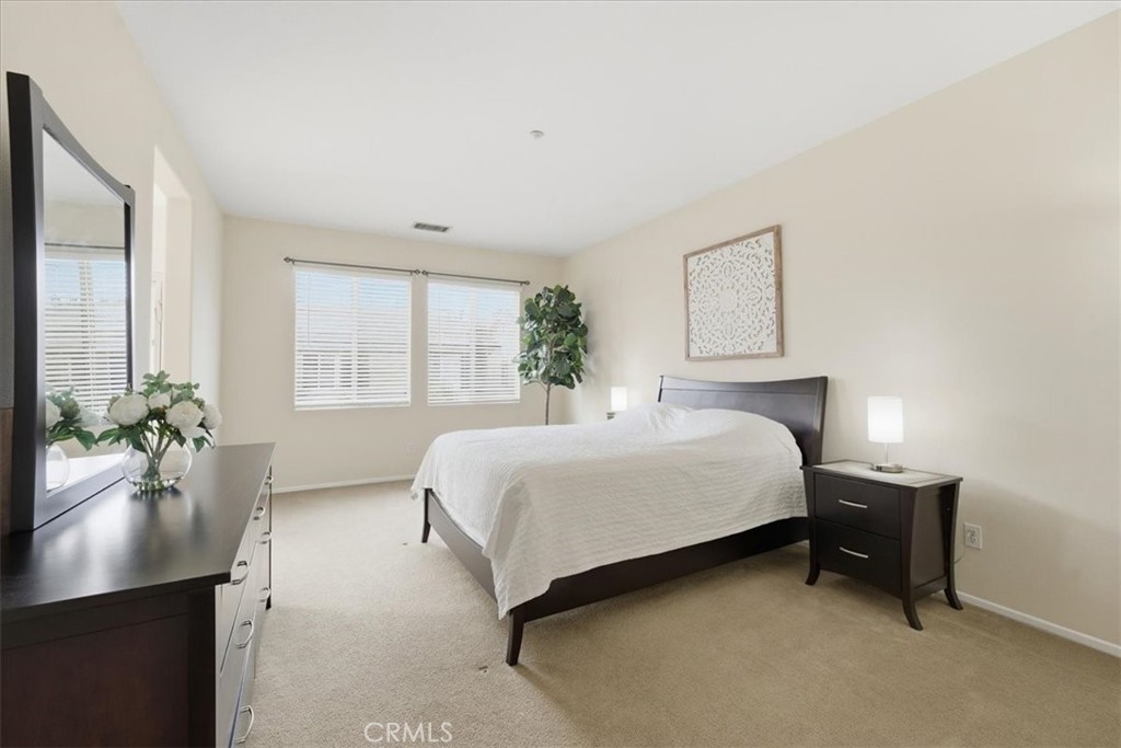 4674 Trailmore Court Riverside, CA 92505 - Photo 19 of 45 a spacious bedroom with a bed and a window