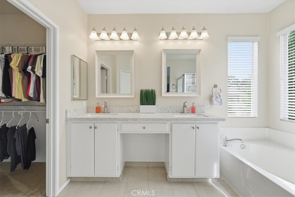 4674 Trailmore Court Riverside, CA 92505 - Photo 21 of 45 a bathroom with a double vanity sink tub and a mirror