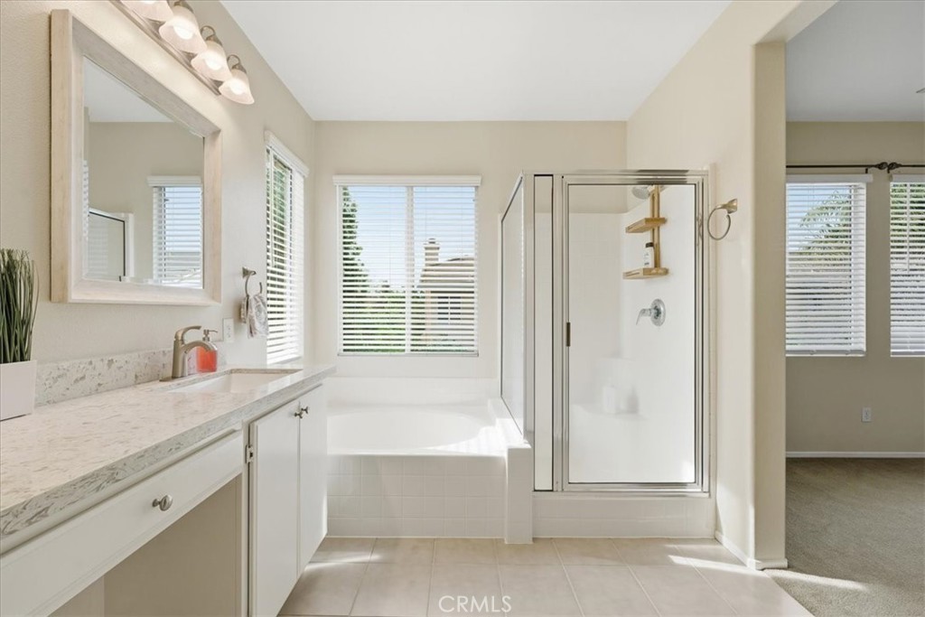 4674 Trailmore Court Riverside, CA 92505 - Photo 23 of 45 a bathroom with a tub sink and mirror