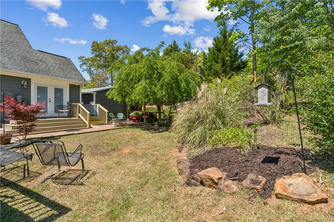 189 Little Choestoea Road Westminster, SC 29693 - Photo 32 of 38 This tranquil yard features a beautiful deck and lush landscaping, perfect for outdoor enjoyment.