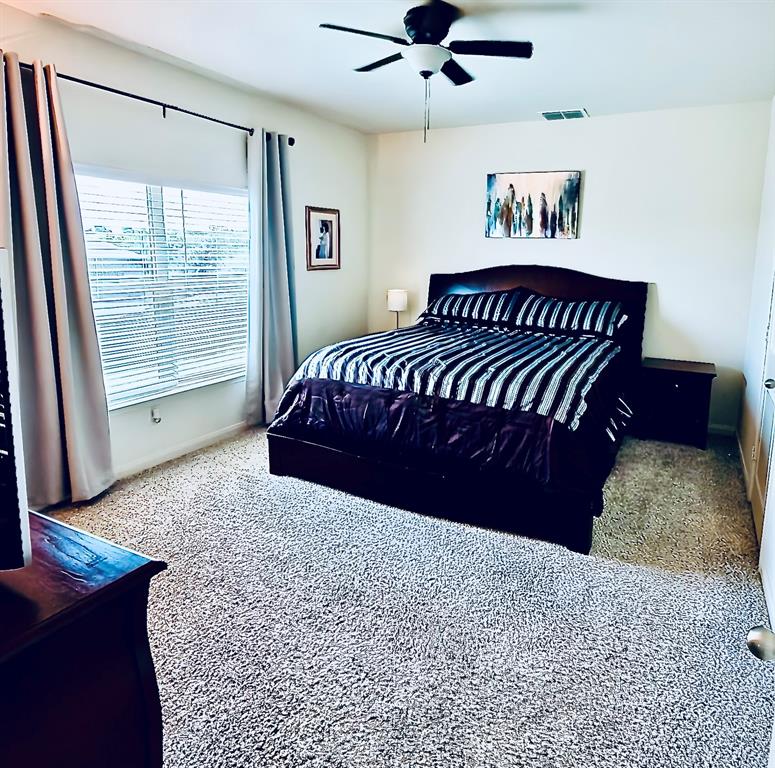 196 Cattlemans Crk Road West Newark, TX 76071 - Photo 11 of 31 Spacious room featuring neutral carpeting, a large window with blinds and drapes, and a ceiling fan with integrated lighting