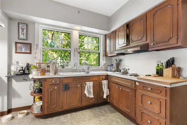 a kitchen with a sink stove top oven and cabinets
