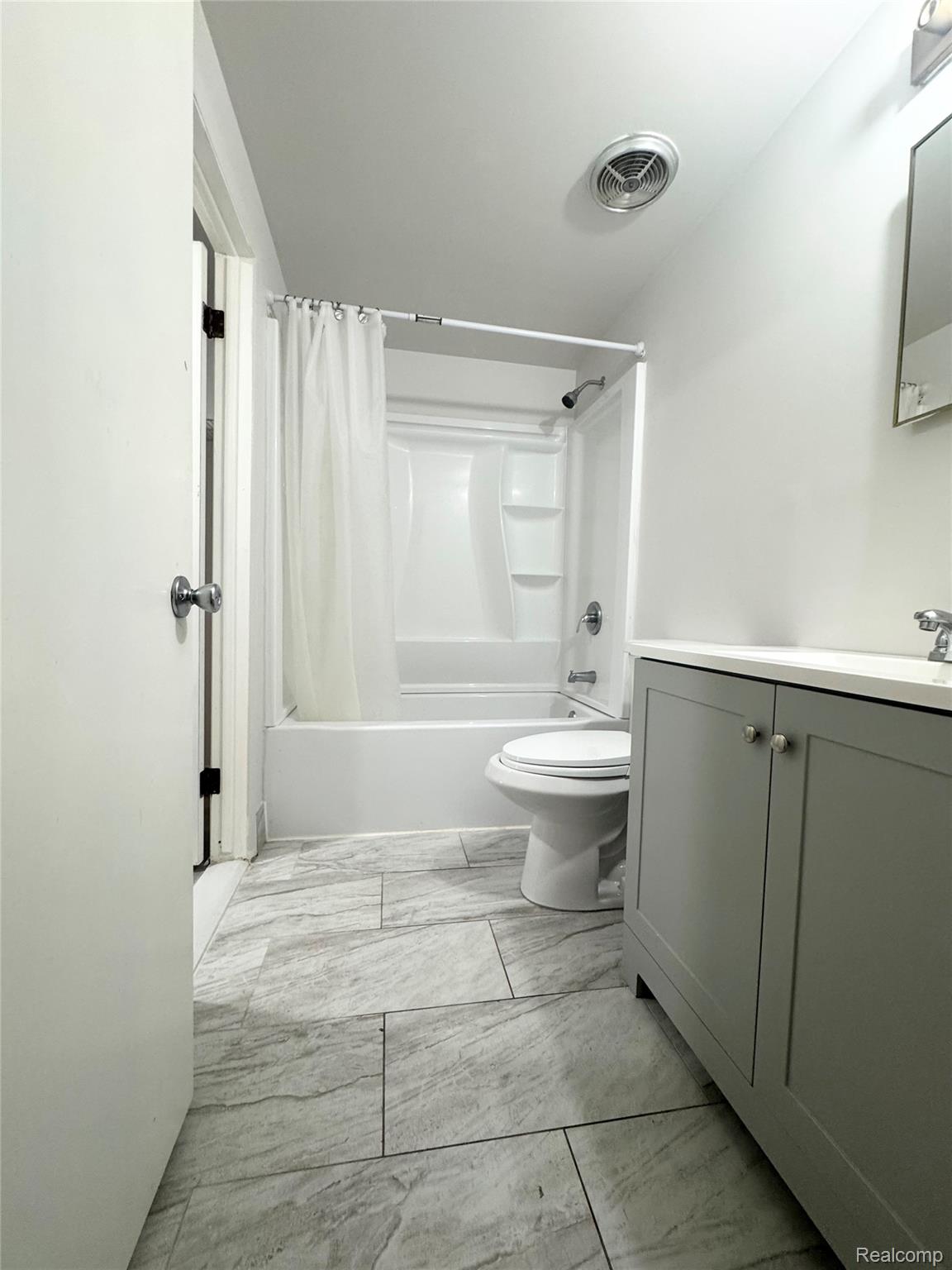 4386 15 Mile Road, Unit 64 Sterling Heights, MI 48310 - Photo 9 of 23 Bathroom featuring a light gray vanity with a white countertop, a white toilet, and a white bathtub with an integrated shower