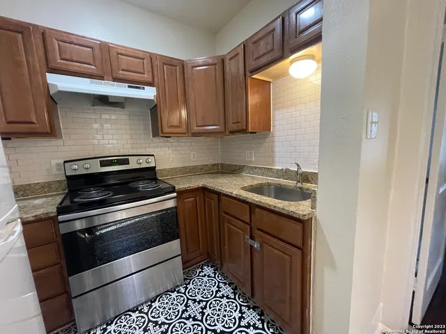 a kitchen with a sink stove and cabinets