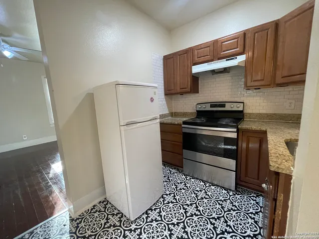a kitchen with a refrigerator and a stove