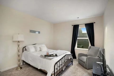 a bedroom with a bed and a large window