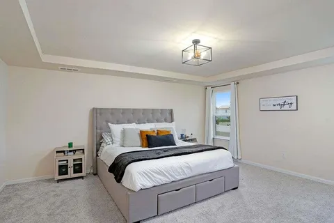 a bedroom with a bed and a chandelier