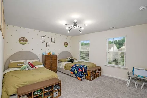 a bedroom with two beds and a window