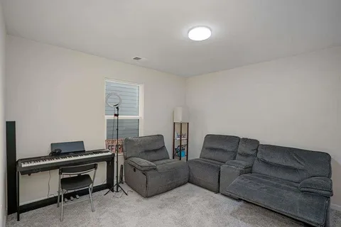 a living room with furniture and a piano