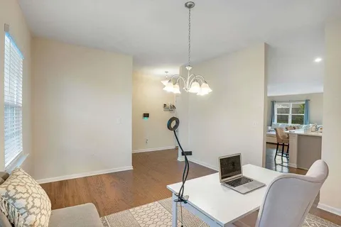 a view of a workspace with furniture and a chandelier