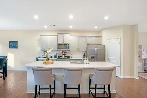 a kitchen with a dining table chairs and refrigerator