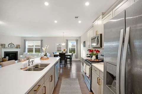 a kitchen with sink stove and refrigerator