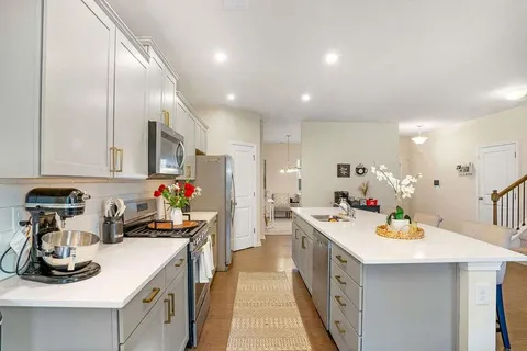 a kitchen that has a lot of cabinets in it and wooden floors