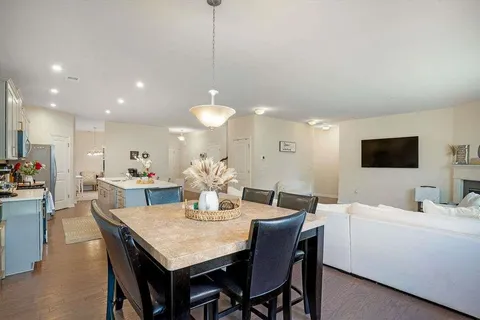 a view of a dining room and a kitchen with a table chairs