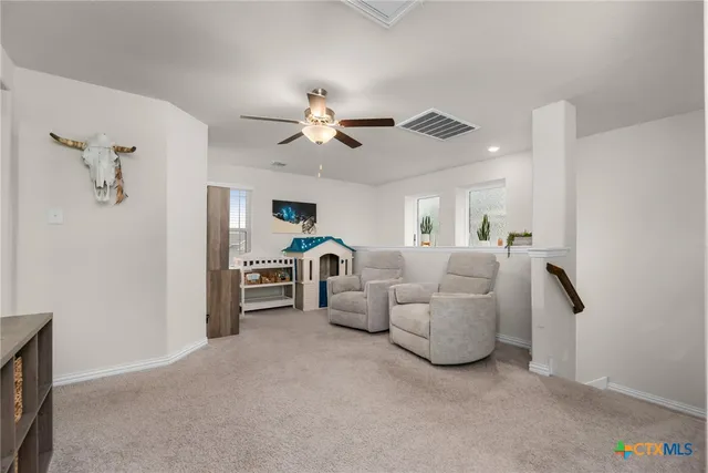 a living room with furniture a ceiling fan and a window