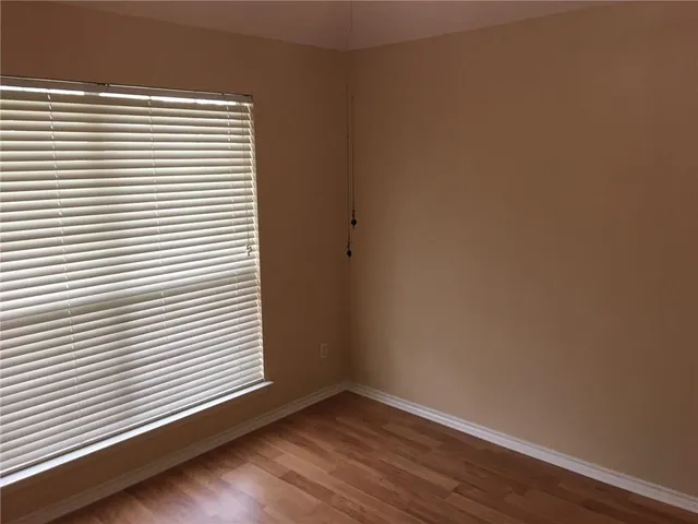 a view of a small space with wooden floor and a window