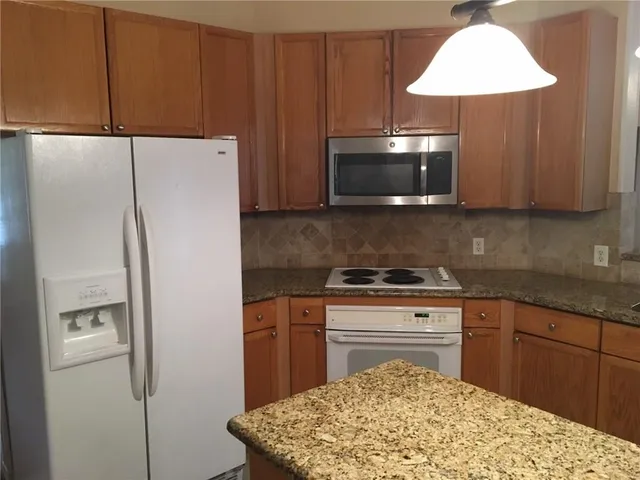 a kitchen with a refrigerator and a stove top oven