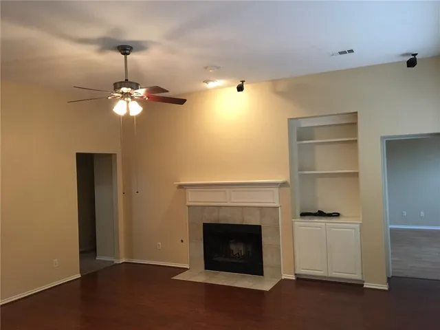 a view of a livingroom with a fireplace a chandelier and wooden floor